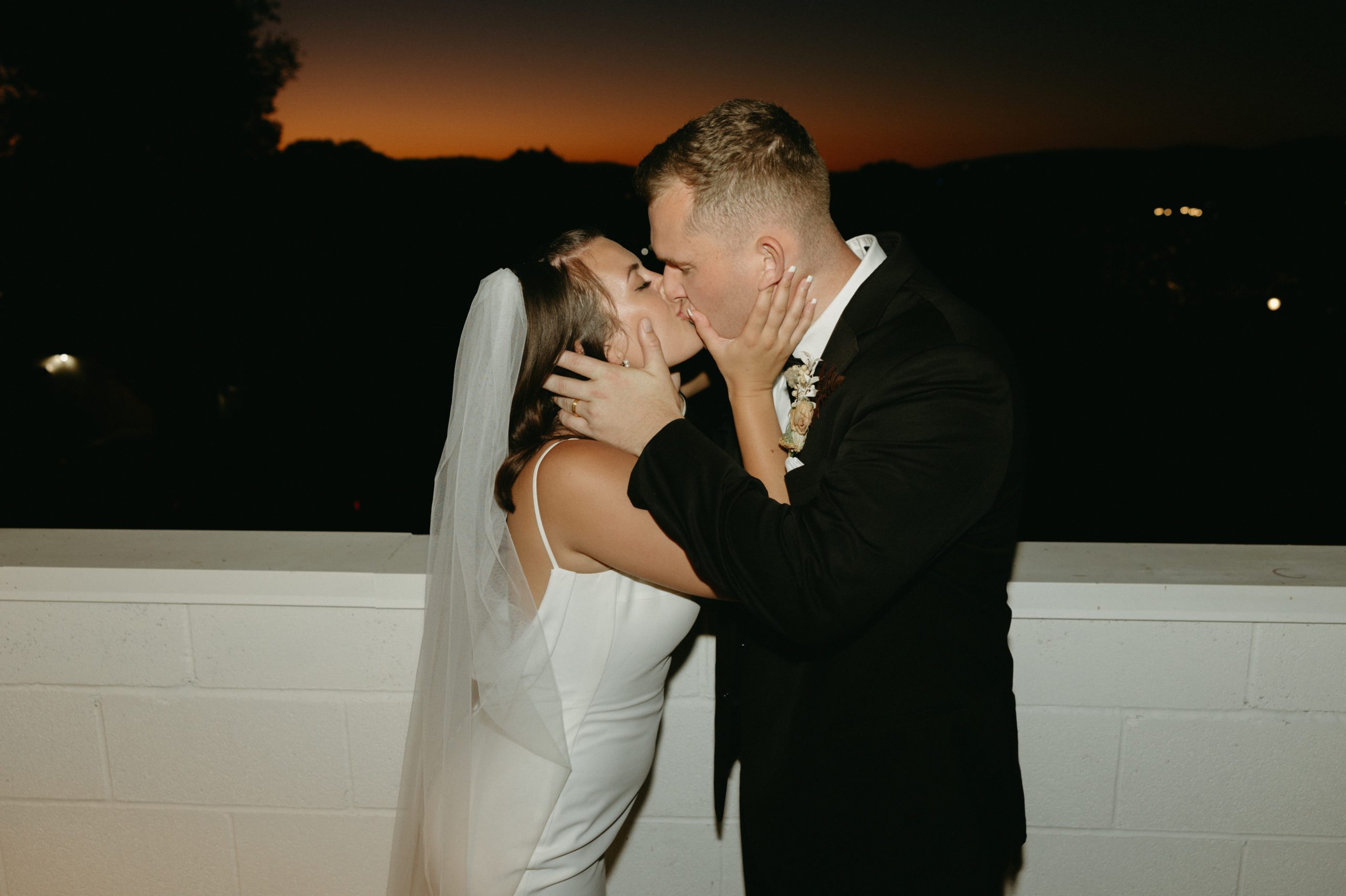 flash photo of bride and groom kissing at wedding