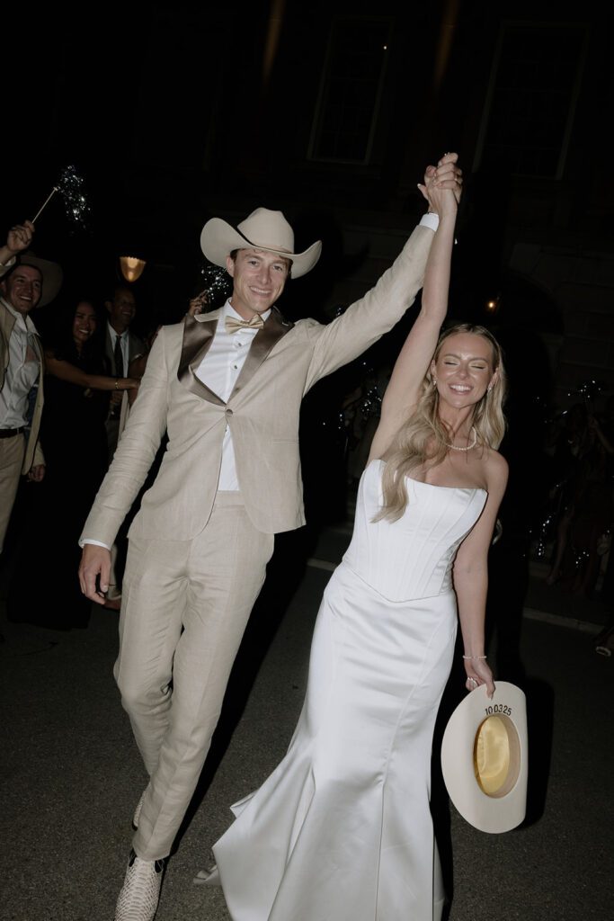 Bride and groom exiting their wedding day with smiles.