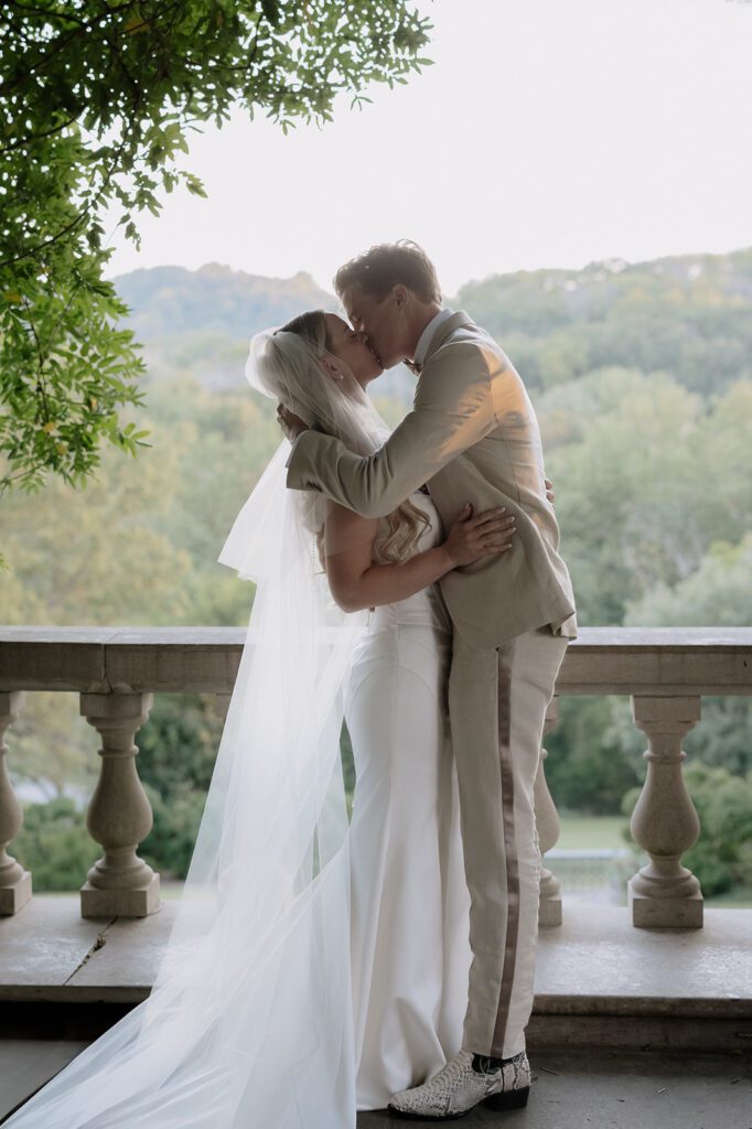 A bride and groom kissing at their wedding ceremony.