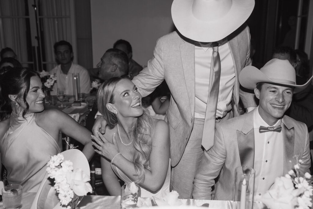 Bride and groom smiling at their wedding guests.
