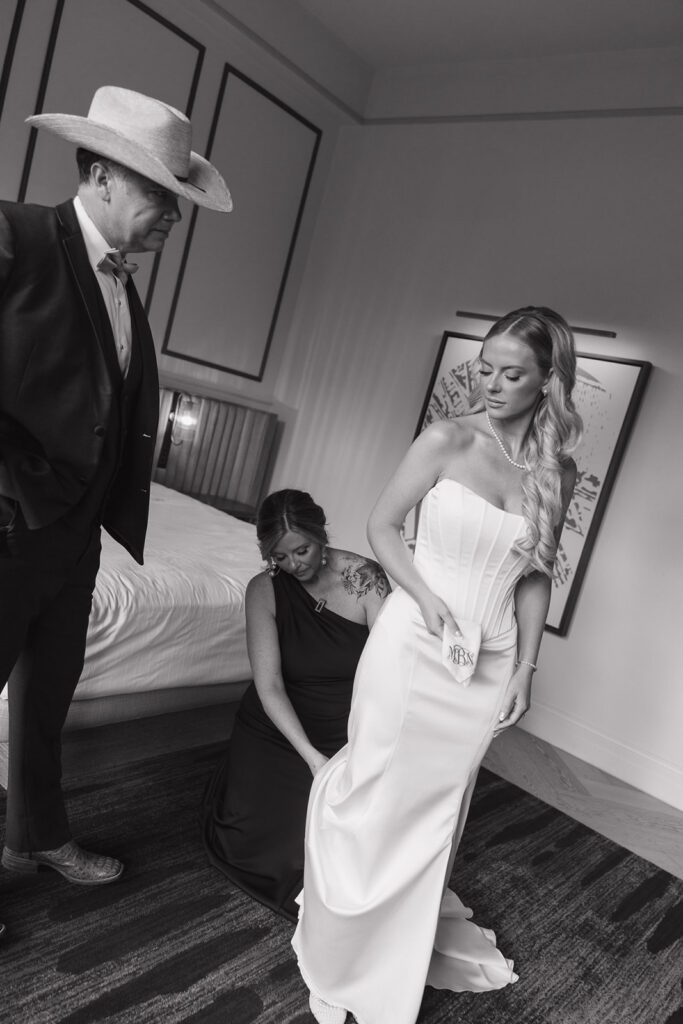 A bride getting ready on her wedding day with her mom and dad.