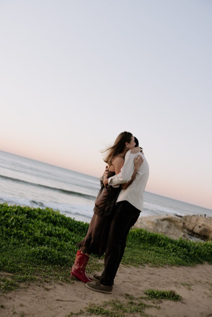 Emmanuel and Camila hugging after the proposal at Sunset Cliffs in San Diego