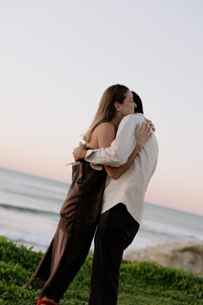 Emmanuel and Camila hugging after the proposal at Sunset Cliffs in San Diego