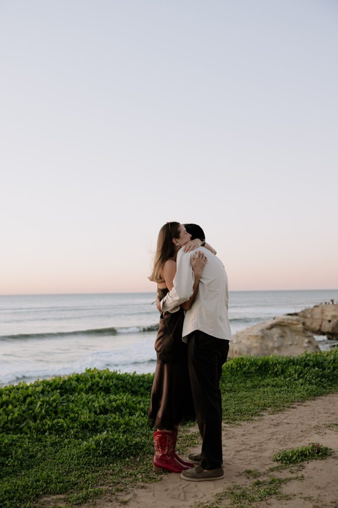 Emmanuel and Camila hugging after the proposal at Sunset Cliffs in San Diego