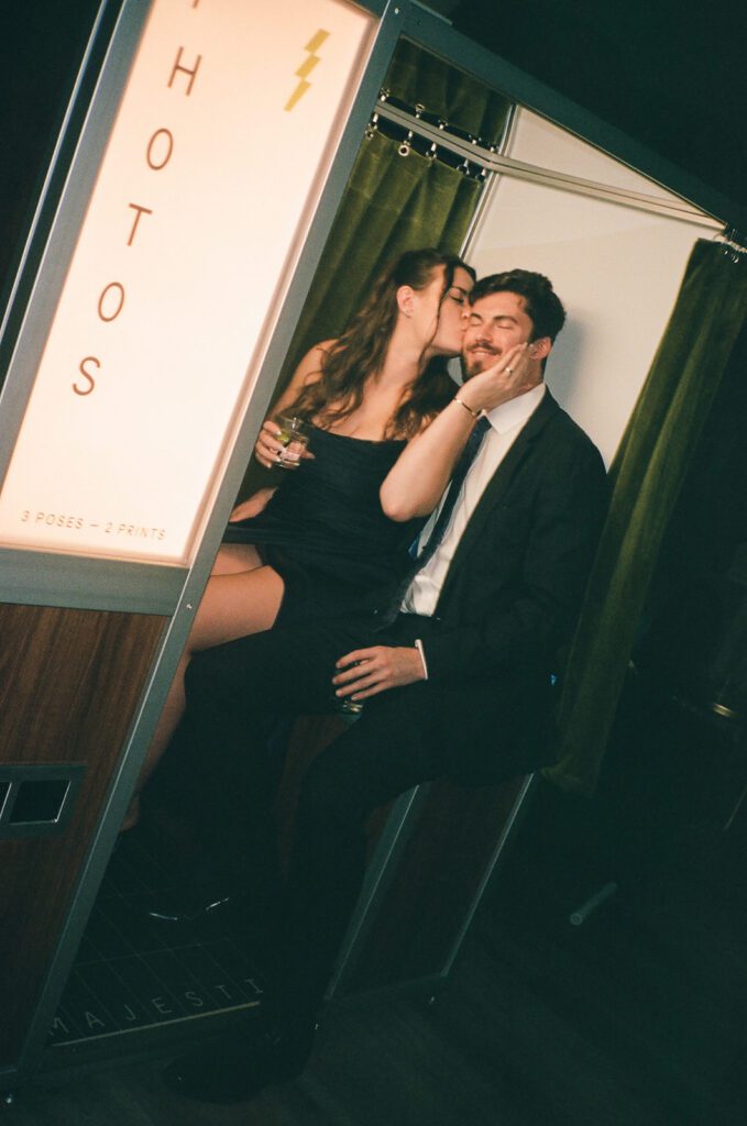 Guests kissing in photobooth at monserate winery wedding
