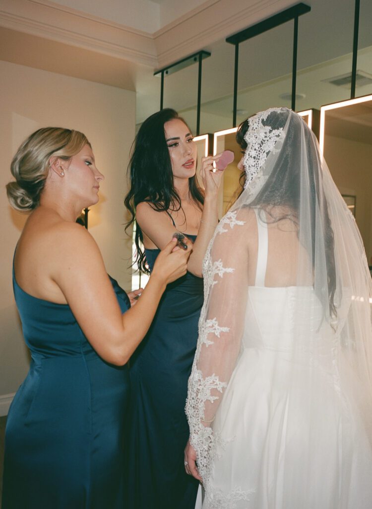 Bride with mom and sisters getting ready during Monserate Winery wedding morning